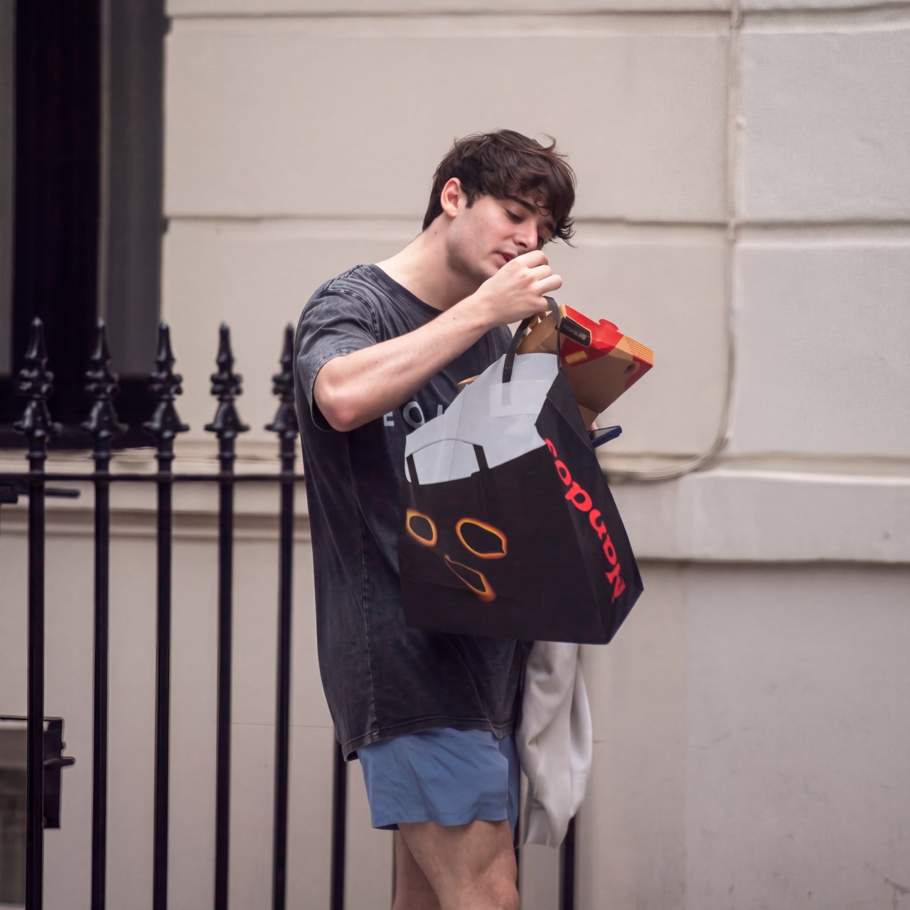 Noah Schnapp and Sheridan Townsley walking together after the gym, Noah holding a Nando's takeaway bag