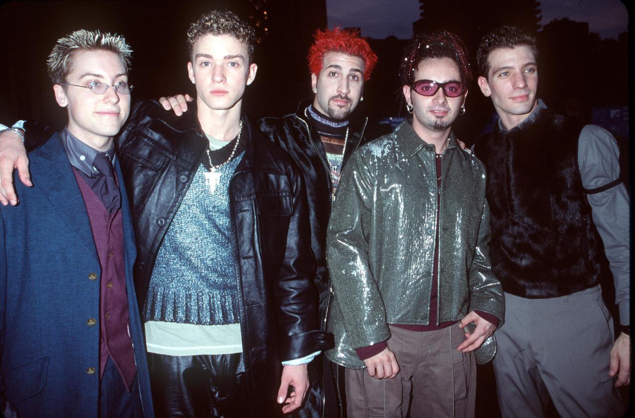Five young men from NSYNC pose together at the 1999 MTV Video Music Awards in New York City, dressed in late-90s fashion.